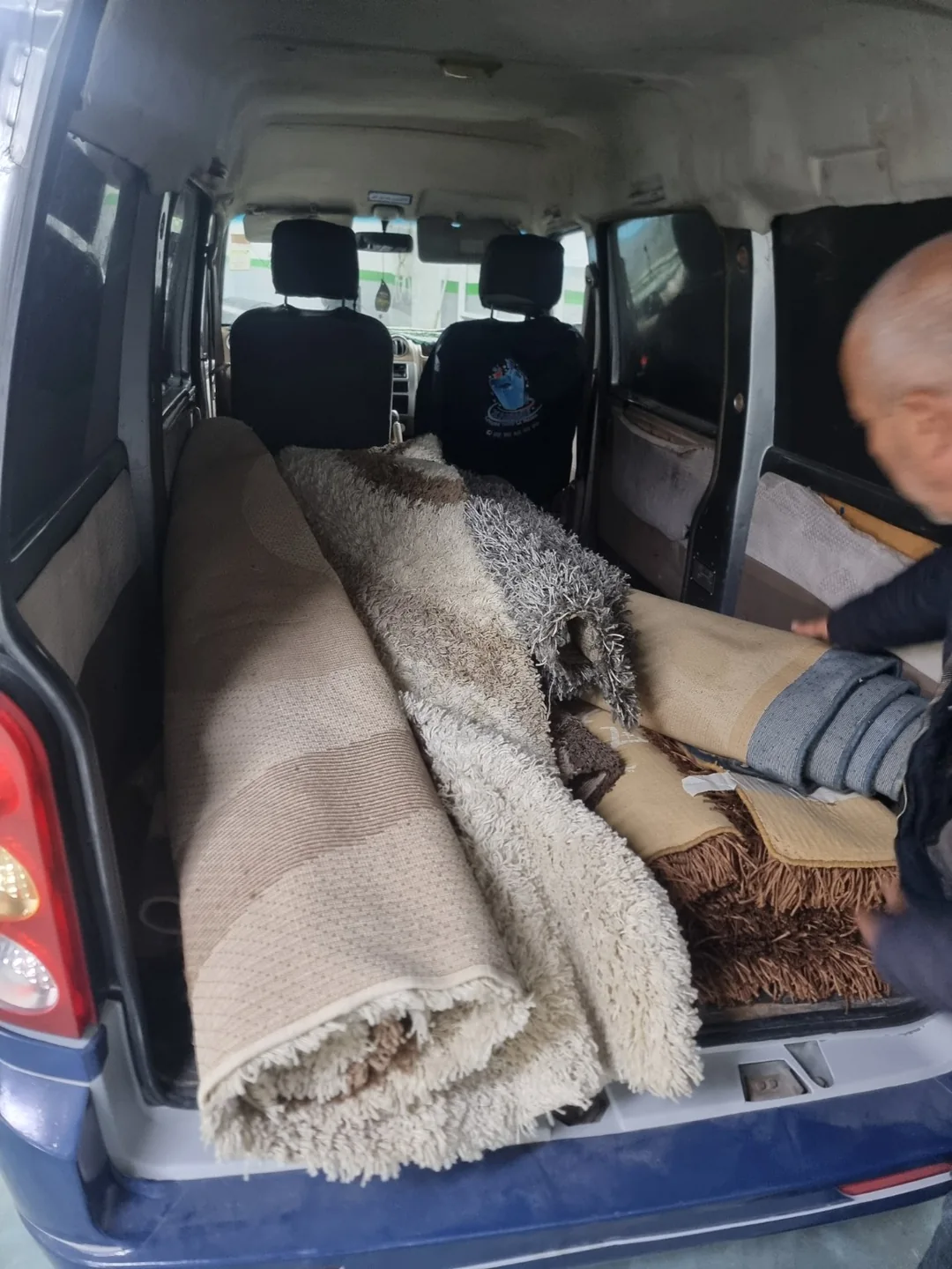 Plusieurs tapis roulés et chargés dans le véhicule ZARBIATI pour leur transport